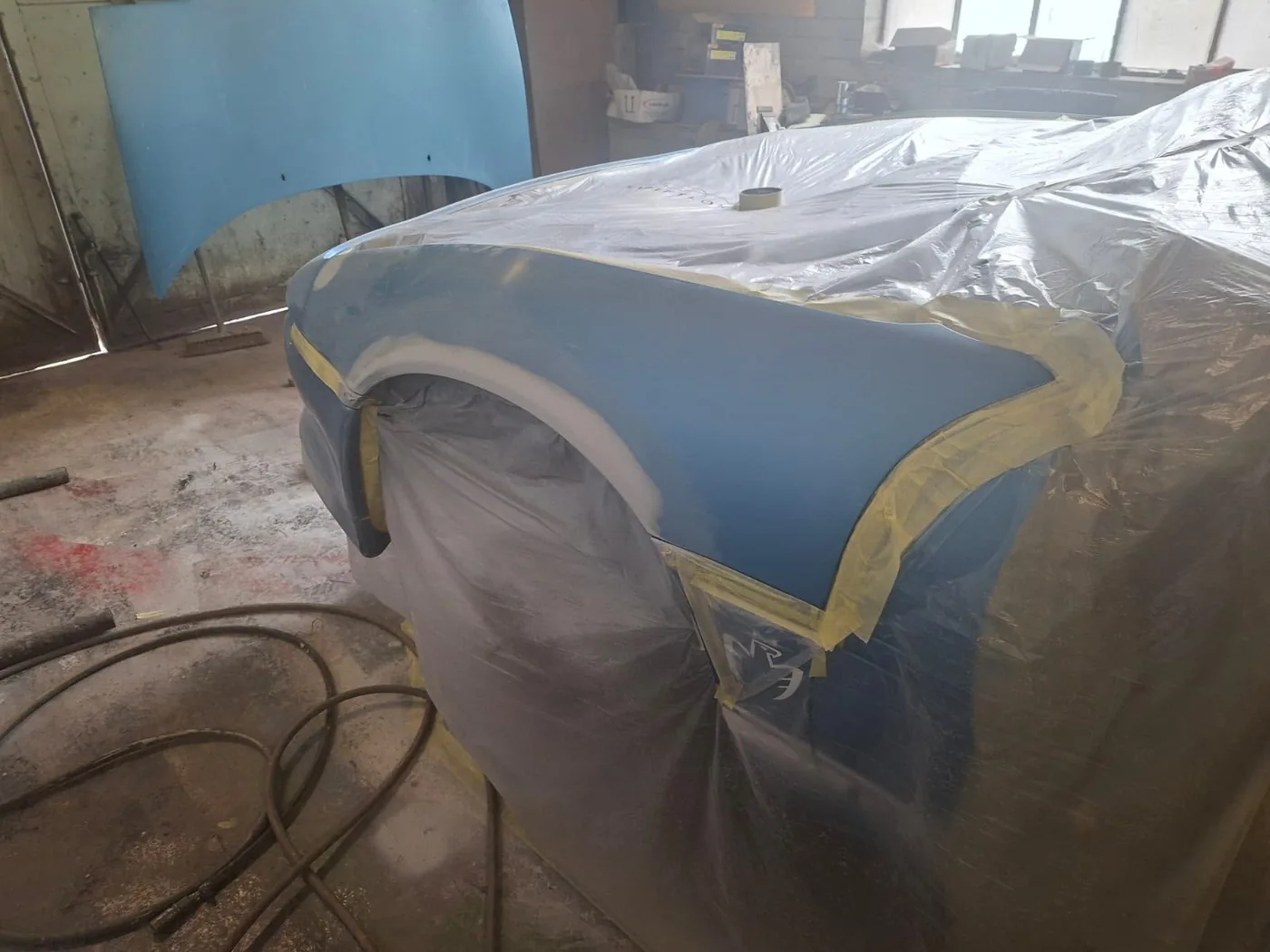 Wing panel in primer, masked and ready for colour